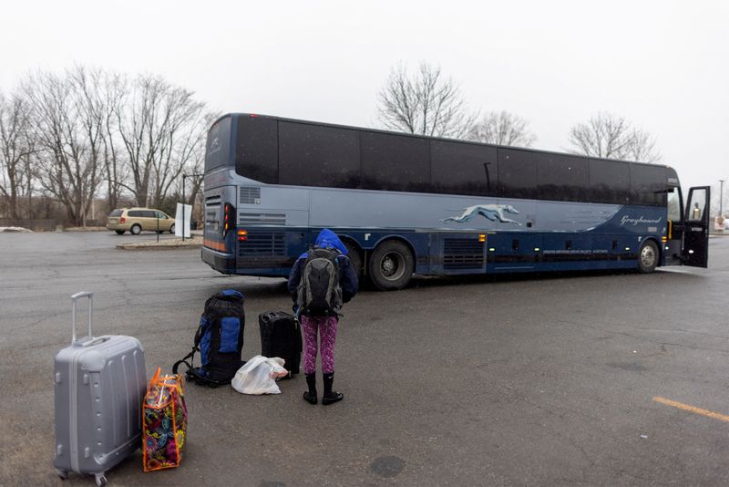 &copy; Reuters. FILE PHOTO: A young person waits with their families belongings after getting off a bus and waiting for a taxi to cross into Canada at Roxham Road, an unofficial crossing point from New York State to Quebec, in Plattsburgh, New York, U.S. March 25, 2023. 