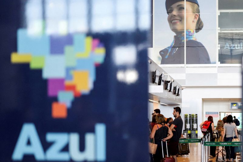 &copy; Reuters. FILE PHOTO: Passengers stand near a Brazilian airline Azul signage at Viracopos International Airport, in Campinas, Sao Paulo State, Brazil, March 16, 2020. REUTERS/Rahel Patrasso/File Photo