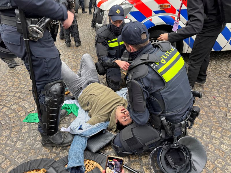 © Reuters. Dutch police help a pro-Palestinian protester during a banned demonstration in Amsterdam, November 10, 2024. REUTERS/Anthony Deutsch