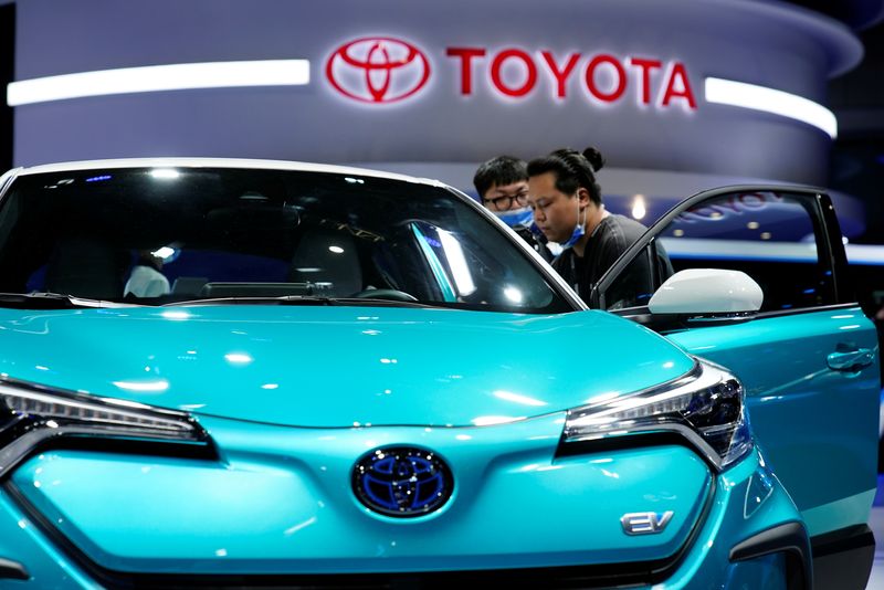 © Reuters. FILE PHOTO: Visitors check a Toyota C-HR electric vehicle (EV) during a media day for the Auto Shanghai show in Shanghai, China April 19, 2021. REUTERS/Aly Song/File Photo