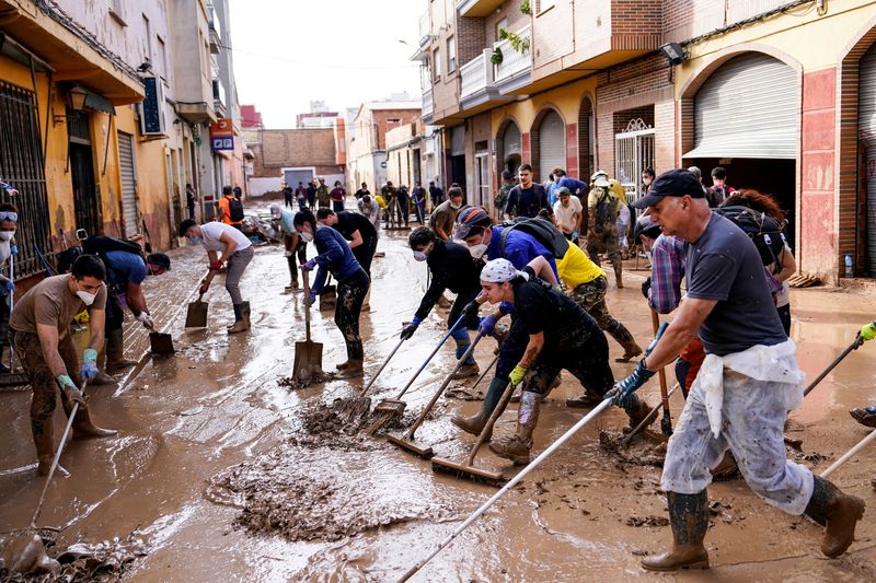 © Reuters. FILE PHOTO: People clean a muddy street in the aftermath of the flooding caused by heavy rains in Massanassa, Valencia, Spain, November 8, 2024. REUTERS/Ana Beltran/File Photo