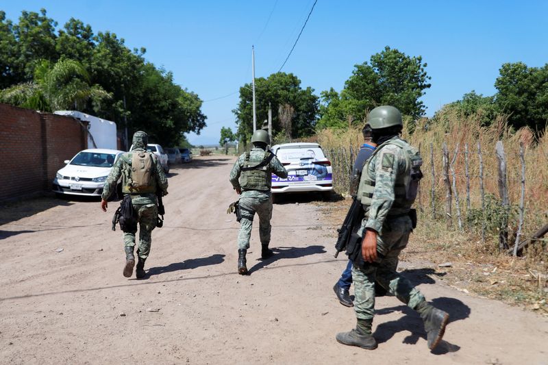 © Reuters. FILE PHOTO: Federal forces guard the perimeter of a scene following a shootout where several suspected gang members were killed while one local cartel leader was arrested, on the outskirts of Culiacan, Sinaloa state, Mexico October 22, 2024. REUTERS/Jose Betanzos/File Photo