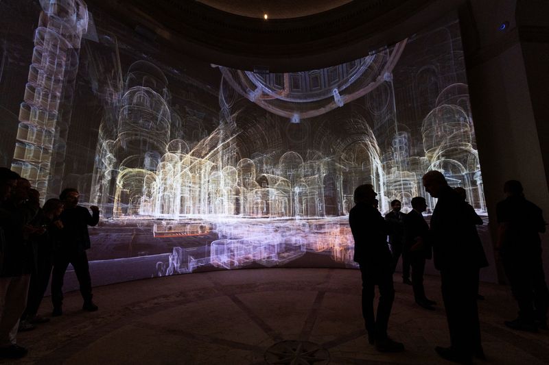 © Reuters. Visitantes observam imagens geradas por IA de corredores e salas dentro da Basílica de São Pedro enquanto o Vaticano apresenta uma nova experiência aprimorada por IA
09/11/2024
REUTERS/Remo Casilli