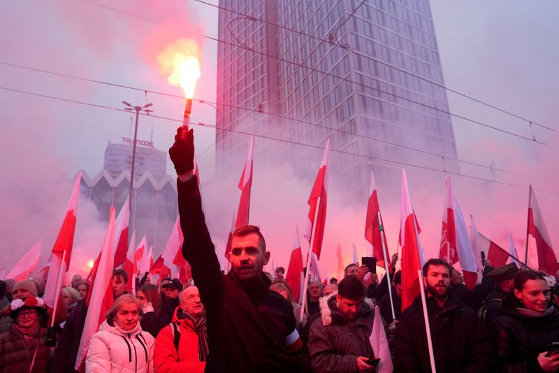 © Reuters. A demonstrator holds a flare during the Independence March to mark the 106th anniversary of Polish independence, in Warsaw, Poland November 11, 2024. REUTERS/Aleksandra Szmigiel