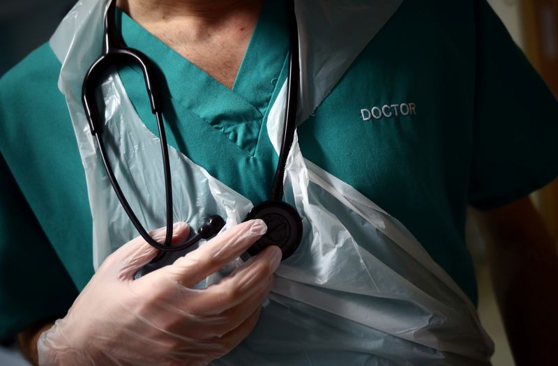 © Reuters. FILE PHOTO: A Junior Doctor holds his stethoscope during a patient visit on Ward C22 at The Royal Blackburn Teaching Hospital in East Lancashire, following the outbreak of the coronavirus disease (COVID-19), in Blackburn, Britain, May 14, 2020. REUTERS/Hannah McKay/Pool/ File Photo