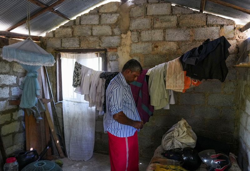 © Reuters. FILE PHOTO: Sudath Kumara, 50, puts on a shirt inside the room of his house in Hambantota, Sri Lanka, October 28, 2024. REUTERS/Thilina Kaluthotage/File Photo