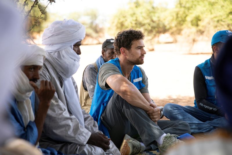 © Reuters. Actor and UNHCR goodwill ambassador Theo James sits during a visit to Aghor, while on a trip with the United Nations refugee agency, in Mauritania, October 9, 2024. UNHCR/Caroline Irby/Handout via REUTERS    