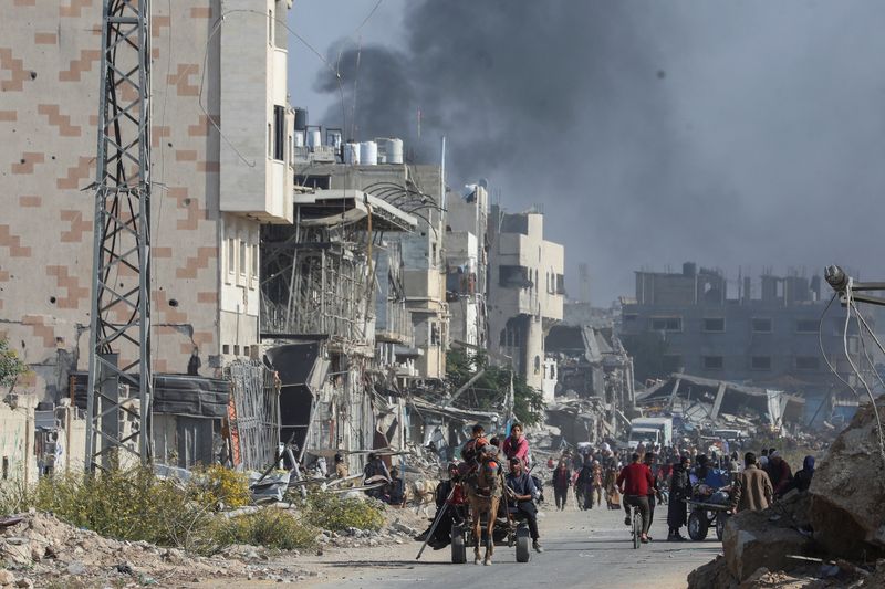 © Reuters. Displaced Palestinians make their way after fleeing the northern part of Gaza amid an Israeli military operation, in Gaza City, November 12, 2024. REUTERS/Dawoud Abu Alkas