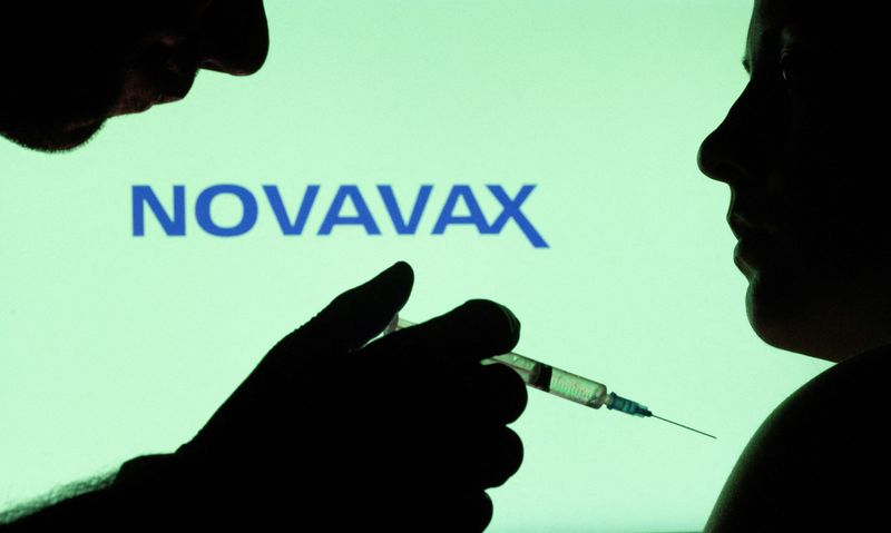 © Reuters. FILE PHOTO: People pose with syringe with needle in front of displayed Novavax logo in this illustration taken, December 11, 2021. REUTERS/Dado Ruvic/Illustration/File Photo