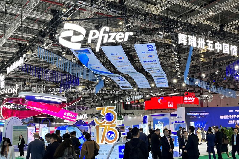 © Reuters. People walk past the booth of drugmaker Pfizer booth at the China International Import Expo (CIIE) in Shanghai, China November 7, 2024. REUTERS/Andrew Silver/File Photo