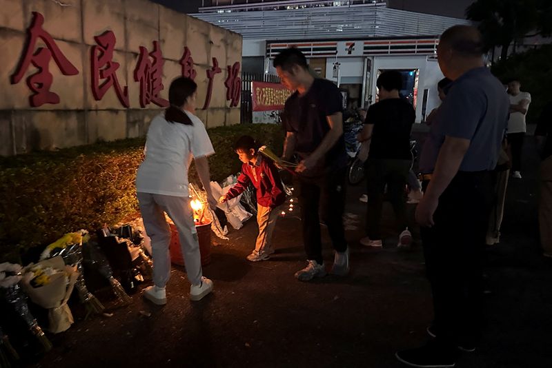 &copy; Reuters. Pessoas queimam incenso e prestam tributos do lado de fora de um centro esportivo onde ocorreu um ataque mortal, em Zhuhai, província de Guangdong, Chinan12/11/2024nREUTERS/Tingshu Wang