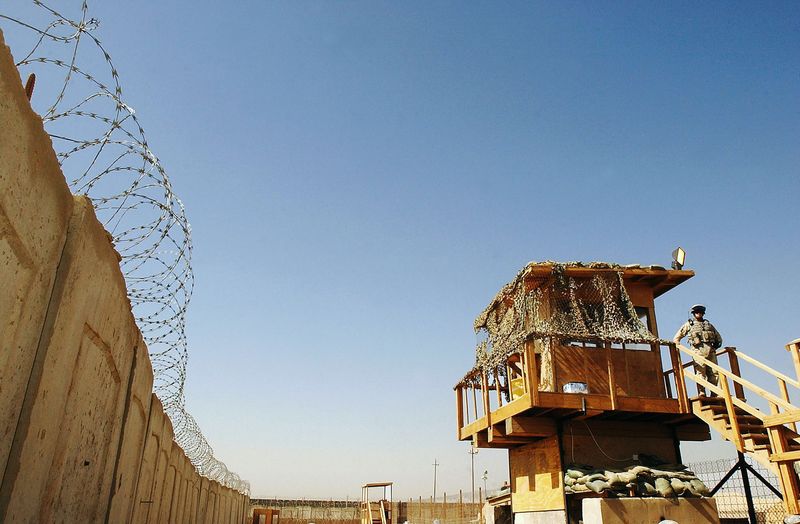 © Reuters. FILE PHOTO: A U.S. soldier stands guard at Abu Ghraib prison west of Baghdad June 19, 2006. REUTERS/Wathiq Khuzaie/Pool/File Photo