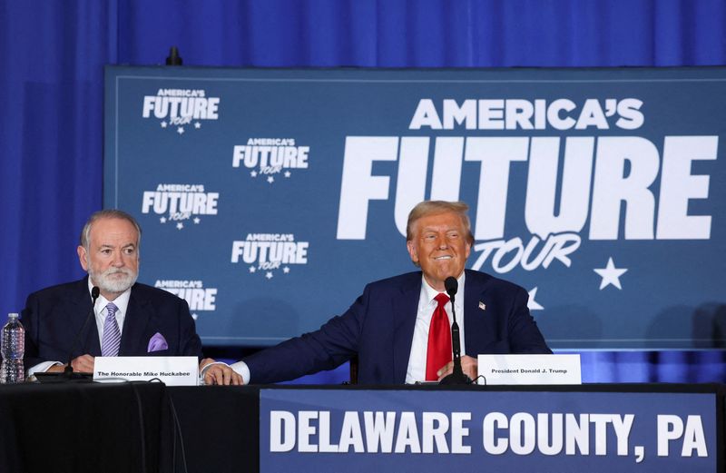 © Reuters. FILE PHOTO: Mike Huckabee looks on as Republican presidential nominee and former U.S. President Donald Trump reacts during a campaign event at the Drexelbrook Catering and Event Center, in Drexel Hill, Pennsylvania, U.S., October 29, 2024. REUTERS/Brendan McDermid/File Photo