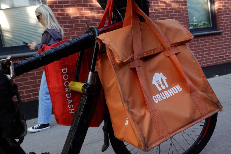 © Reuters. FILE PHOTO: Doordash and Grubhub delivery bags are seen on a bicycle in Brooklyn, New York City, U.S., May 9, 2022. REUTERS/Andrew Kelly/File Photo