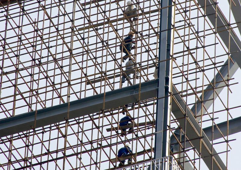 © Reuters. FILE PHOTO: Labourers work on scaffolding of a construction site of a residential and commercial complex in Beijing, China, September 18, 2015. REUTERS/Kim Kyung-Hoon/File Photo