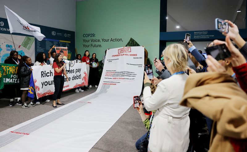 © Reuters. Activists display a 10 metre long climate invoice directed at developed countries at a protest during the United Nations Climate Change Conference (COP29), in Baku, Azerbaijan November 14, 2024. REUTERS/Maxim Shemetov