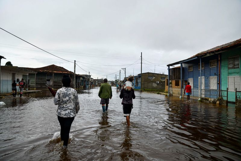 © Reuters. FILE PHOTO: People walk in a flooded street a day after Hurricane Rafael made landfall, in Batabano, Cuba, November 7, 2024. REUTERS/ REUTERS/Norlys Perez/File Photo