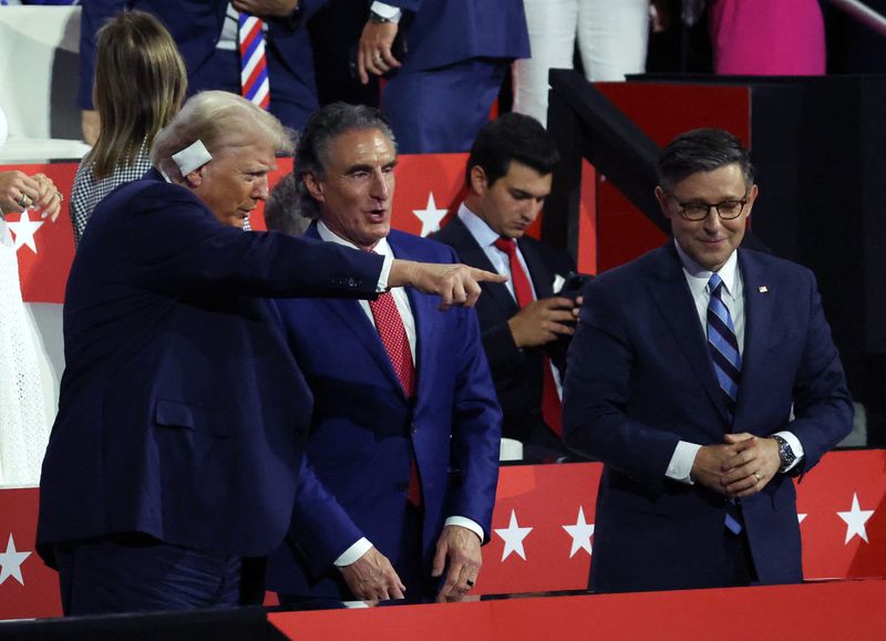 © Reuters. Republican presidential nominee and former U.S. President Donald Trump gestures as Doug Burgum, Governor of North Dakota, and House Speaker Mike Johnson look on, on Day 3 of the Republican National Convention (RNC), at the Fiserv Forum in Milwaukee, Wisconsin, U.S., July 17, 2024. REUTERS/Jeenah Moon/File Photo