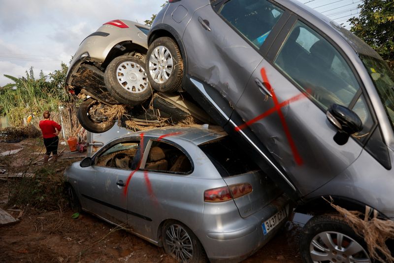 © Reuters. Joaquina, a Honduran migrant who has lost her shack after flooding caused by heavy rains, stands near a piel of cars in the De la Torre neighbourhood of Valencia, Spain, November 14, 2024. REUTERS/Eva Manez