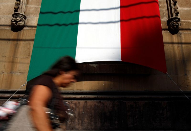 &copy; Reuters. FILE PHOTO: A woman walks past a Mexico's national flag in downtown Mexico City September 14, 2012.  REUTERS/Tomas Bravo/File Photo