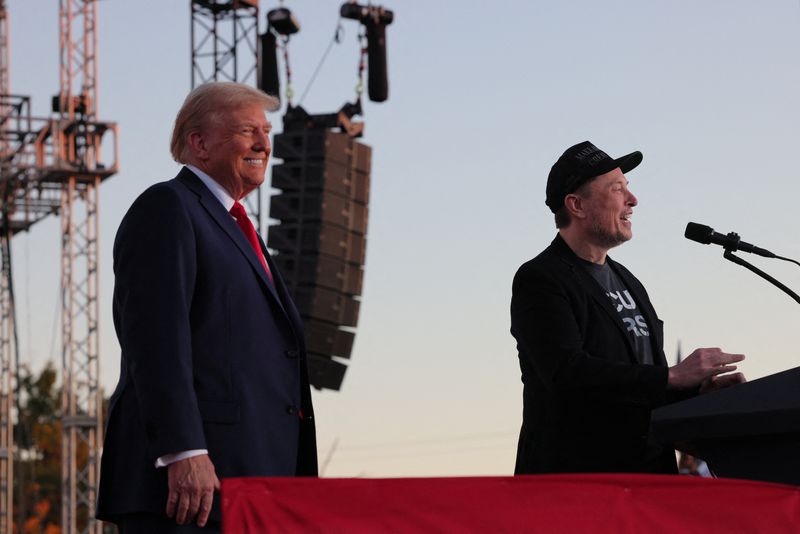 © Reuters. FILE PHOTO: Tesla CEO and X owner Elon Musk speaks as Republican presidential nominee and former U.S. president Donald Trump looks on during a rally at the site of the July assassination attempt against Trump, in Butler, Pennsylvania, U.S., October 5, 2024. REUTERS/Brian Snyder/File Photo