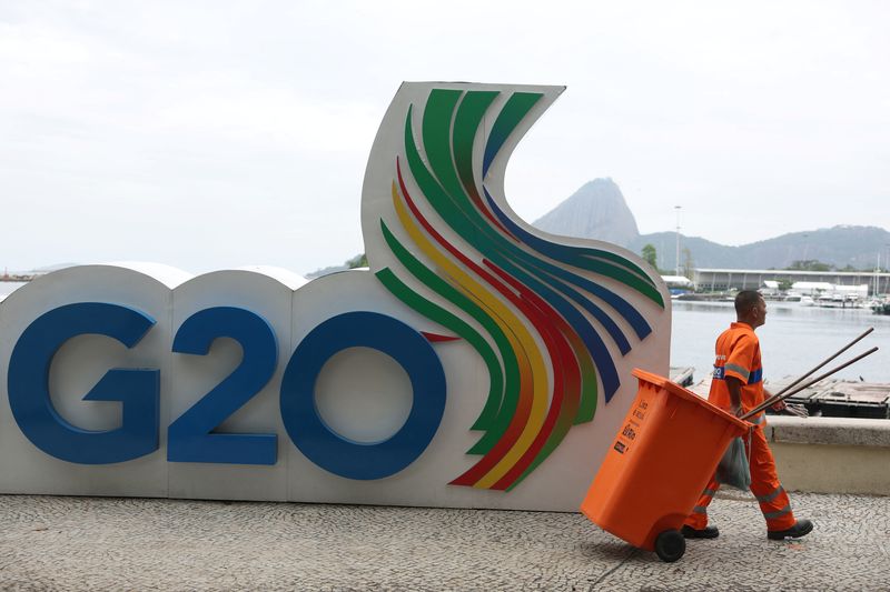 © Reuters. FILE PHOTO: A cleaning staff walks past a G20 Summit sign outside the Museum of Modern Art (MAM), the venue of the G20 summit, in Rio de Janeiro, Brazil November 14, 2024. REUTERS/Pilar Olivares/ File Photo