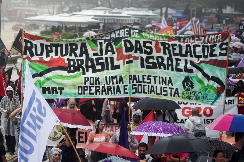 © Reuters. People hold a banner, as they take part in a social movements and unions protest in solidarity with Palestinians in Gaza, amid the Israel-Hamas conflict, ahead of the G20 Summit, in Rio de Janeiro, Brazil November 16, 2024. REUTERS/Tita Barros