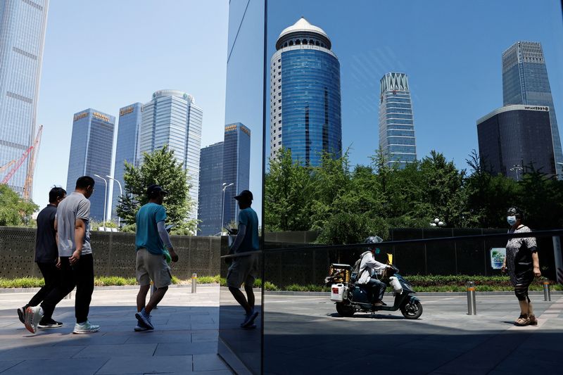 © Reuters. FILE PHOTO: People walk past Beijing's Central Business District, in Beijing, China June 21, 2023. REUTERS/Tingshu Wang/File Photo