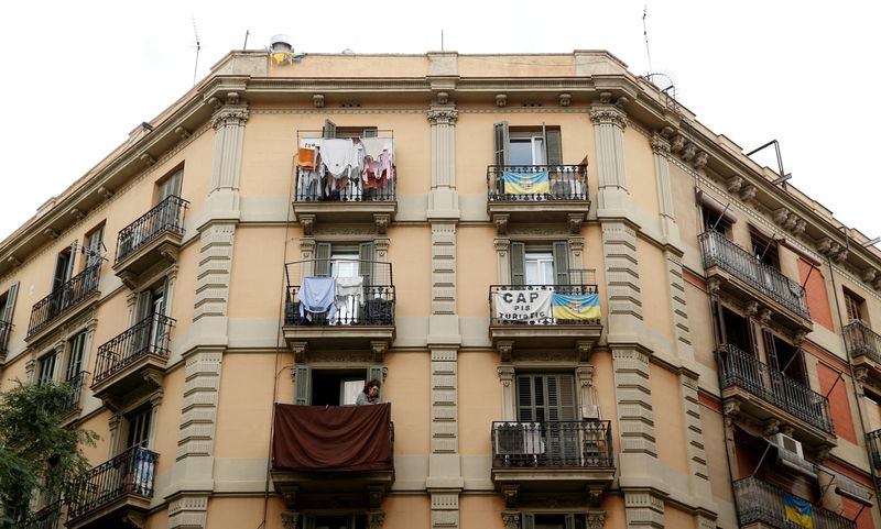 &copy; Reuters. FILE PHOTO: A banner against apartments for tourists hangs from a balcony as a woman tend clothes at Barceloneta neighborhood in Barcelona, Spain, November 28, 2016. The banner reads "No tourists apartments". REUTERS/Albert Gea/File Photo