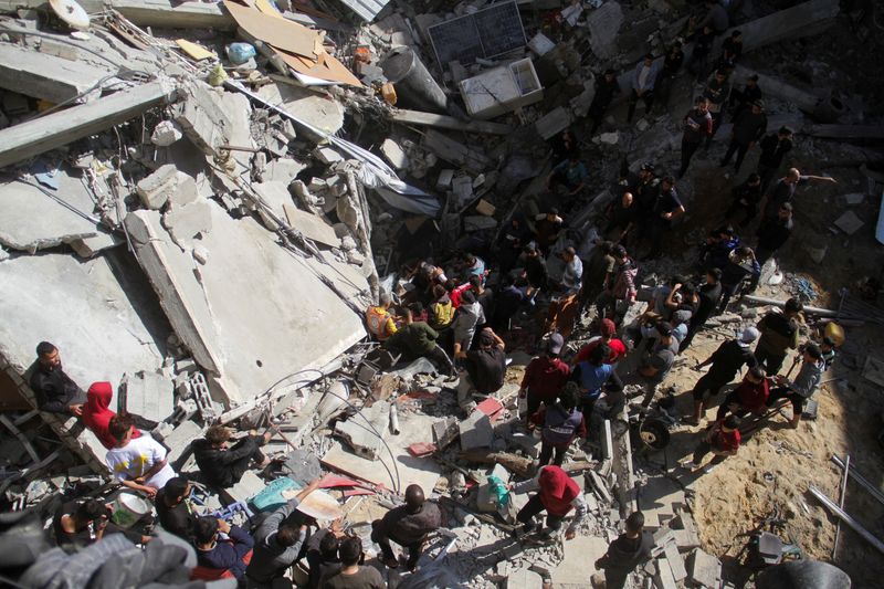 © Reuters. Palestinians, including rescuers, search for casualties at the site of an Israeli strike on a house, in Gaza City November 18, 2024. REUTERS/Mahmoud Issa