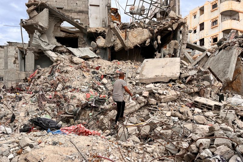 &copy; Reuters. Palestinian man Moein Abu Odeh searches for clothes through the rubble of a house destroyed in the Israeli military offensive, in Khan Younis in the southern Gaza Strip, November 18, 2024. REUTERS/Hussam Al-Masri     TPX IMAGES OF THE DAY