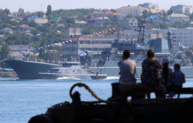 &copy; Reuters. FILE PHOTO: People watch a rehearsal for Russia's Navy Day parade in the Black Sea port of Sevastopol, Crimea July 26, 2019. REUTERS/Alexey Pavlishak/File Photo