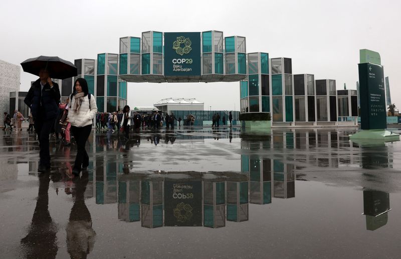 © Reuters. People walk at the entrance of the venue of the United Nations climate change conference COP29, in Baku, Azerbaijan November 18, 2024. REUTERS/Murad Sezer/File Photo