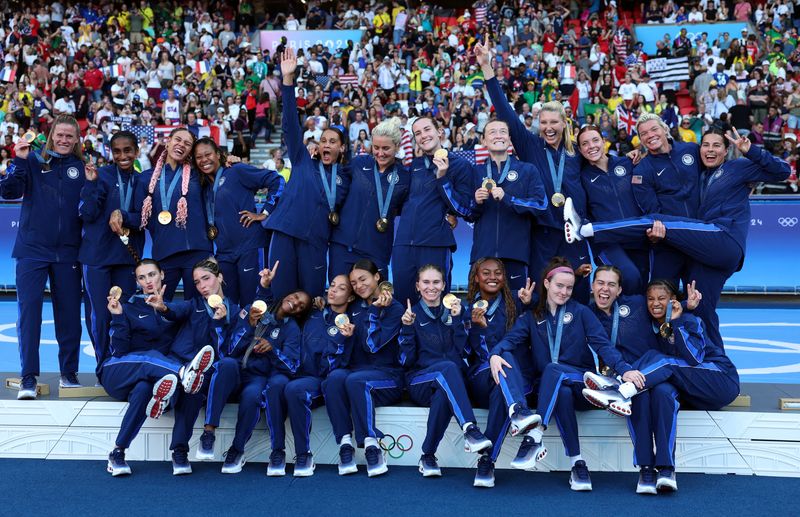 © Reuters. FILE PHOTO: Paris 2024 Olympics - Football - Women's Victory Ceremony - Parc des Princes, Paris, France - August 10, 2024. Gold medallists of United States celebrate on the podium. REUTERS/Isabel Infantes/File Photo