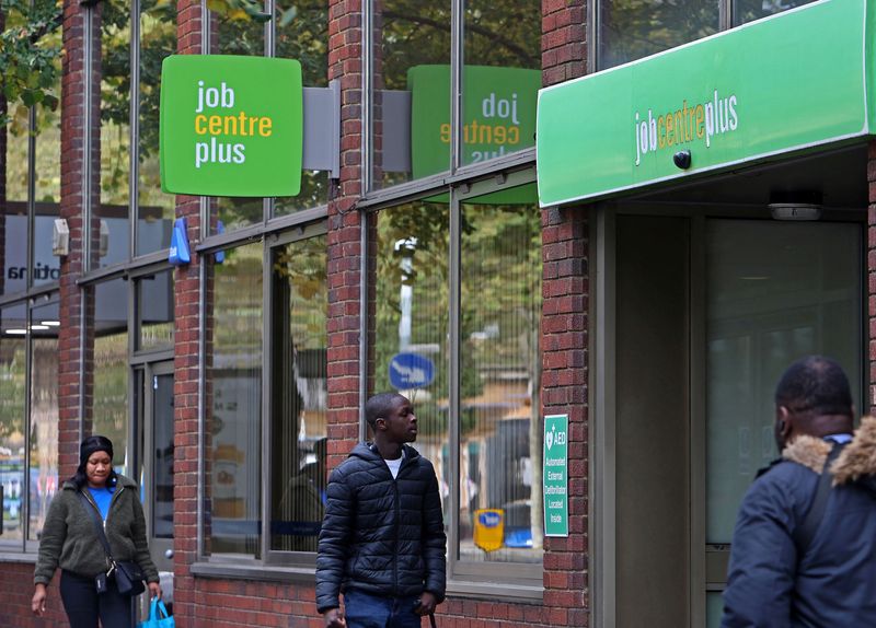 © Reuters. FILE PHOTO: People walk alongside a Job Centre Plus in London, Britain, October 25, 2023.  REUTERS/ Susannah Ireland/File Photo