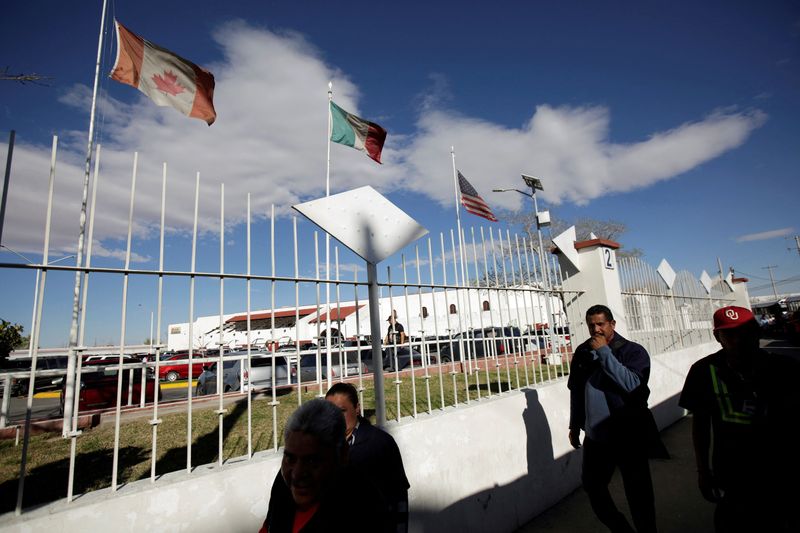 &copy; Reuters. FILE PHOTO: Workers walk by the flags of Canada, Mexico and U.S. flying at an assembly factory in Ciudad Juarez, Mexico March 9, 2018. REUTERS/Jose Luis Gonzalez/File Photo