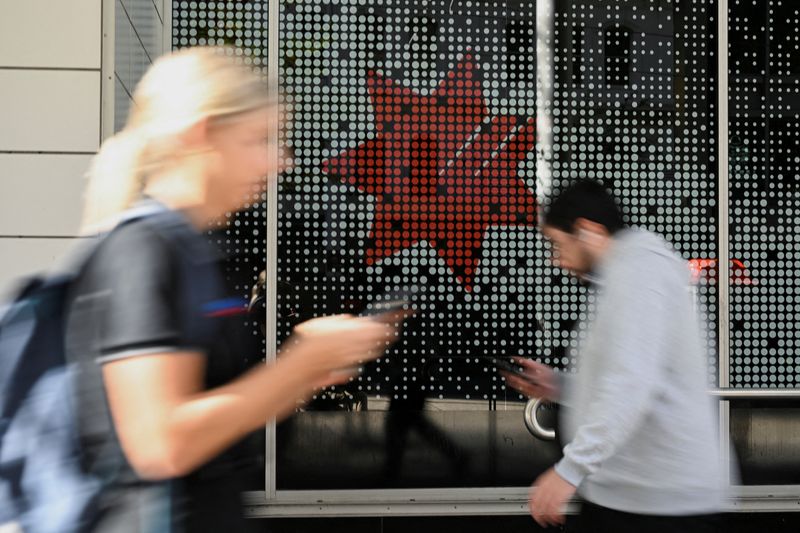 &copy; Reuters. FILE PHOTO: People walk past a NAB building in the Sydney Central Business District, in Sydney, Australia, May 14, 2024. REUTERS/Jaimi Joy/File Photo