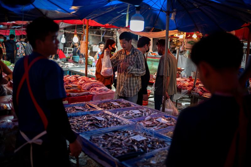 © Reuters. FILE PHOTO: A man buys foods at a market as Thailand is to inject $15.2 bln into economy next year through its digital wallet policy, in Bangkok, Thailand, October 2, 2023. REUTERS/Athit Perawongmetha/File Photo