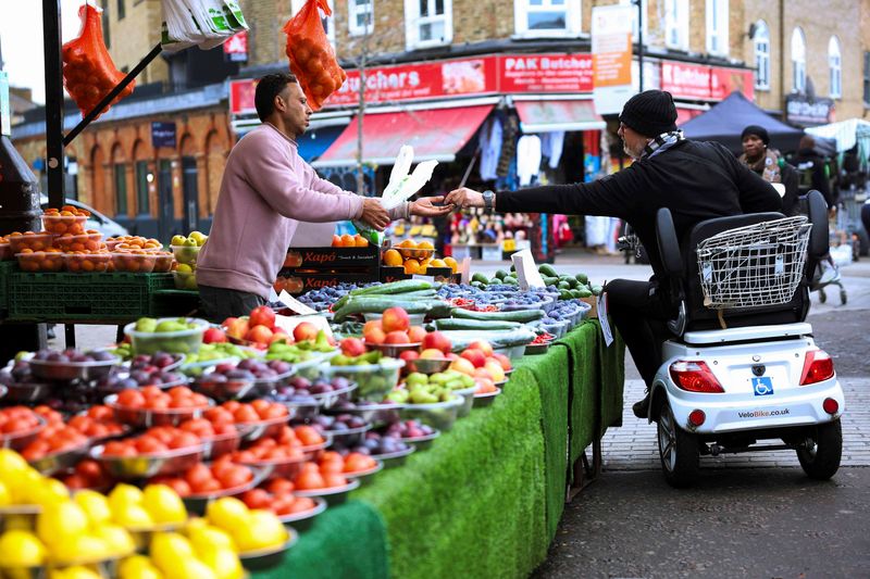 © Reuters. FILE PHOTO: A customer shops for produce at Ridley Road Market, ahead of Labour's budget, in London, Britain, October 28, 2024. REUTERS/Mina Kim/File Photo