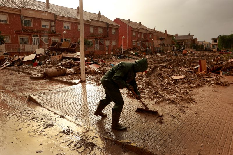 © Reuters. FILE PHOTO: A volunteer clean muddy water following catastrophic flooding, as Spain braces for more torrential rain, in Paiporta, Valencia, Spain November 13, 2024. REUTERS/Vincent West/File Photo