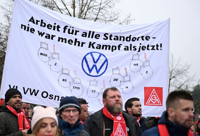 &copy; Reuters. I dipendenti della Volkswagen AG marciano per ottenere salari più alti durante uno "sciopero di avvertimento" del sindacato tedesco dei metalmeccanici IG Metall, a Osnabrück, Germania, il 6 novembre 2024. Il cartello recita: "Lavori per tutti i siti VW 