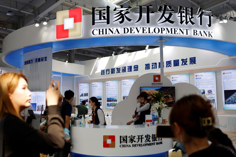 © Reuters. FILE PHOTO: A woman takes pictures of the China Development Bank booth at the 2021 China International Fair for Trade in Services (CIFTIS) in Beijing, China September 3, 2021. REUTERS/Florence Lo/File Photo