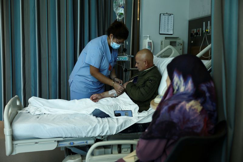 &copy; Reuters. A medical staff assists Ahmad Fahess, a displaced man from the southern Lebanese town of Nabatieh with sarcoma cancer, at the American University of Beirut Medical Center (AUBMC) in Beirut, Lebanon November 20, 2024. REUTERS/Emilie Madi