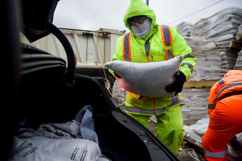 &copy; Reuters. Ricco Anthony, San Francisco Public Works laborer, drops a sandbag into a city resident's car trunk,  as a "bomb cyclone" storm heads for Northern California, in San Francisco, California, U.S., November 20, 2024. REUTERS/Dylan Bouscher