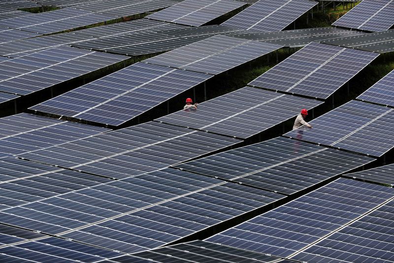 &copy; Reuters. Trabalhadores em parque de energia solar em Chongqingn27/07/2018nREUTERS/Stringe