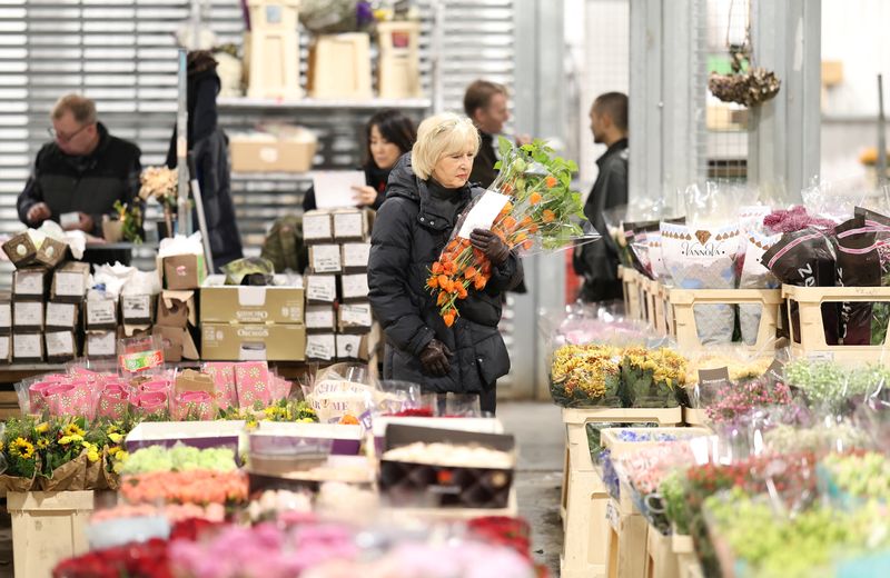 © Reuters. FILE PHOTO: A customer carries a bouquet of flowers at New Covent Garden Market wholesale flower market in London, Britain, October 8, 2024. REUTERS/Mina Kim/File Photo