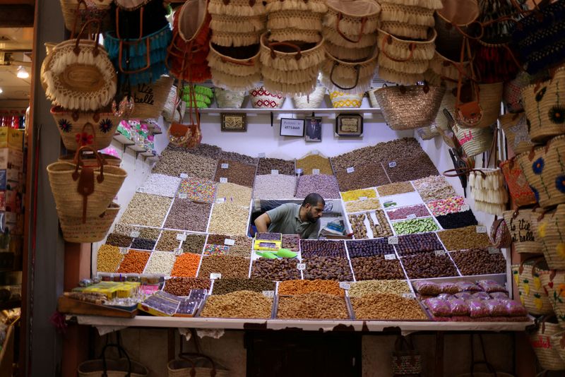 © Reuters. FILE PHOTO: A vendor sits among spices and nuts in his stall in a market in Marrakesh, Morocco, October 22, 2024. REUTERS/Stelios Misinas/File photo