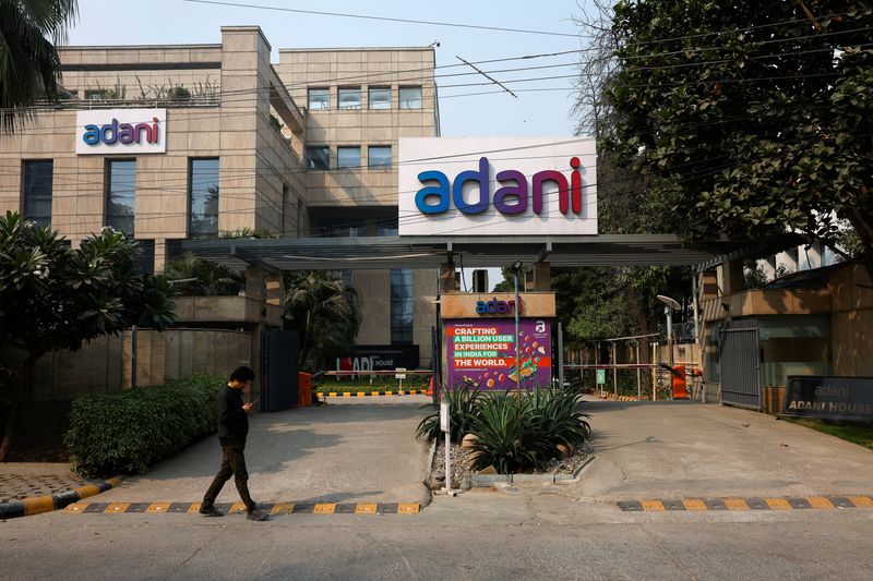 © Reuters. A man walks past a corporate office of Adani Group in Gurugram, India, November 22, 2024. REUTERS/Priyanshu Singh