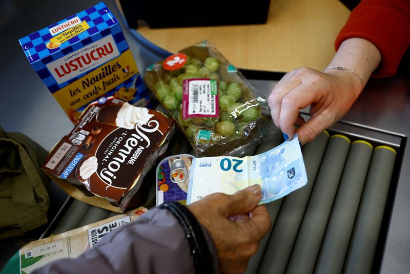 © Reuters. A woman pays with a twenty Euro bank note at the checkout in a supermarket in Chanverrie, France, October 16, 2024. REUTERS/Stephane Mahe/File Photo