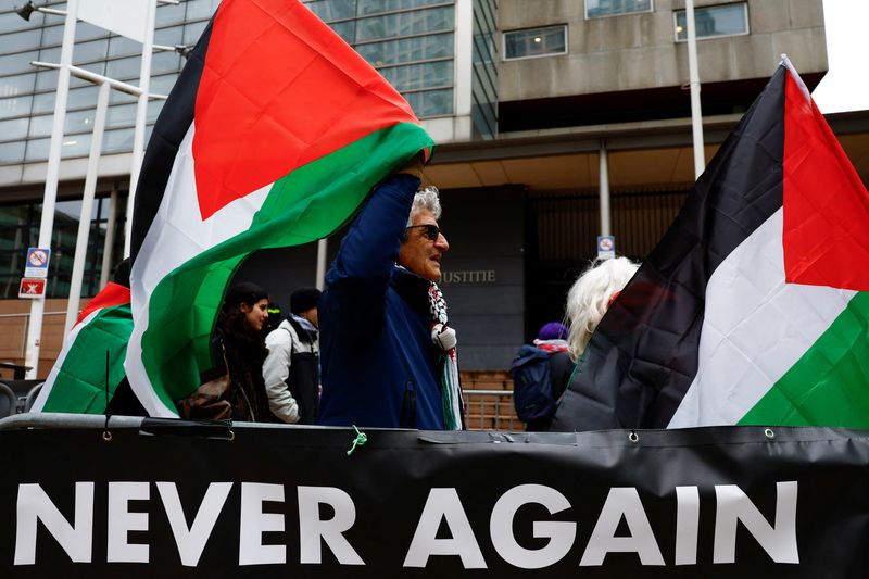 © Reuters. Protesters hold flags outside the court on the day a district court hears the case of pro-Palestinian NGOs who are suing the Dutch state, a staunch ally of Israel, for failing to prevent an alleged genocide in Gaza and what they say are other Israeli violations of international law, in The Hague, Netherlands, November 22, 2024. REUTERS/Piroschka van de Wouw